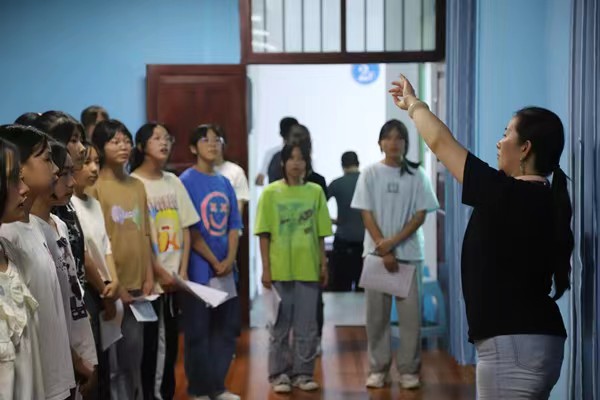 带队教师指导中学生练习齐唱。437必赢会员中心供稿图